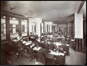 Men and one woman working at desks in an office at the Metropolitan Life Insurance Co. at 23rd Street and Madison Avenue, New York